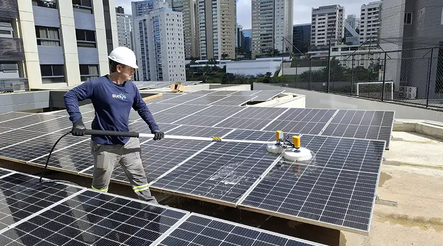 Profissional trabalhando com equipamento para limpeza de placa solar em uma das usinas fotovoltaicas projetadas pela Sunus em Nova Lima - MG
