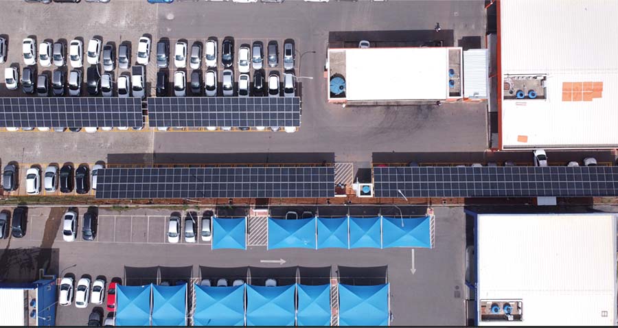 Imagem aérea de estacionamento da Movida Aluguel de Carros com várias vagas de carros cobertas por painéis solares, também conhecidos como carport solar